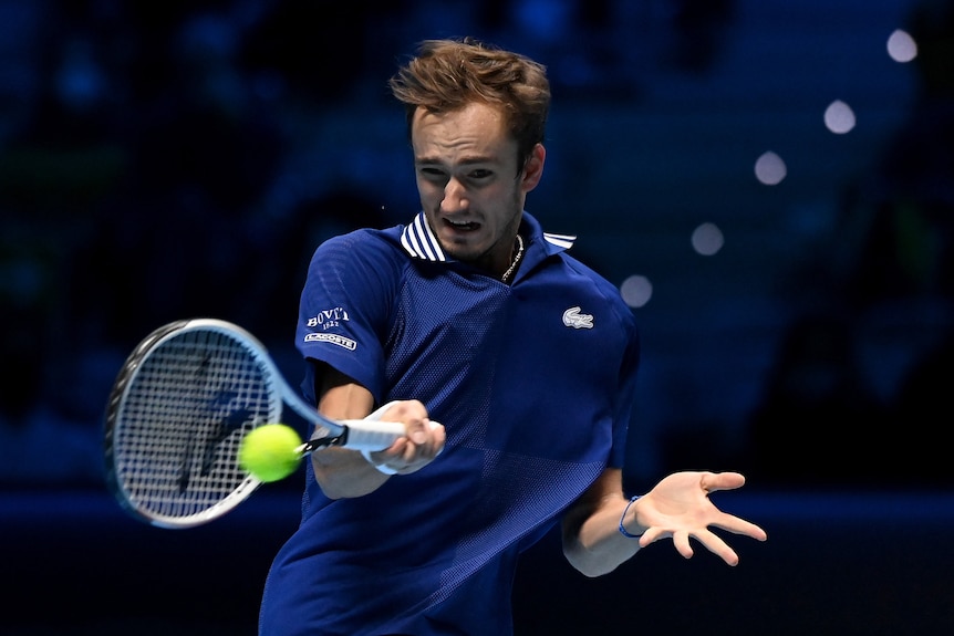 A tennis player grimaces as his racquet connects with the ball for a big forehand return during a match.