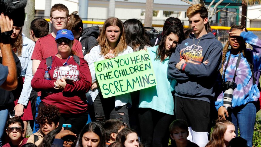 Marjory Stoneman Douglas High students hold signs saying: Can you hear the children screaming