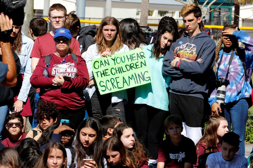 Marjory Stoneman Douglas High students hold signs saying: Can you hear the children screaming