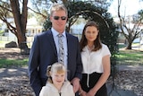 Brad Hudson stands his 16-year-old daughter Megan and younger daughter Amber in Toowoomba
