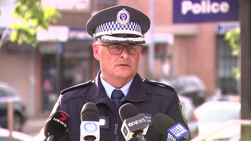 a policeman wearing glasses talking to the media