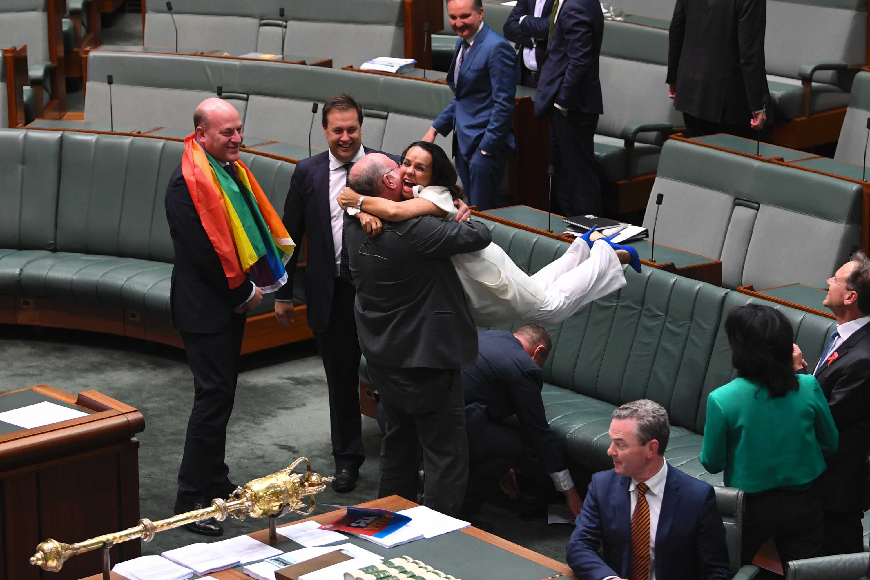 Linda Burney hugs Warren Entsch and throws her feet in the air