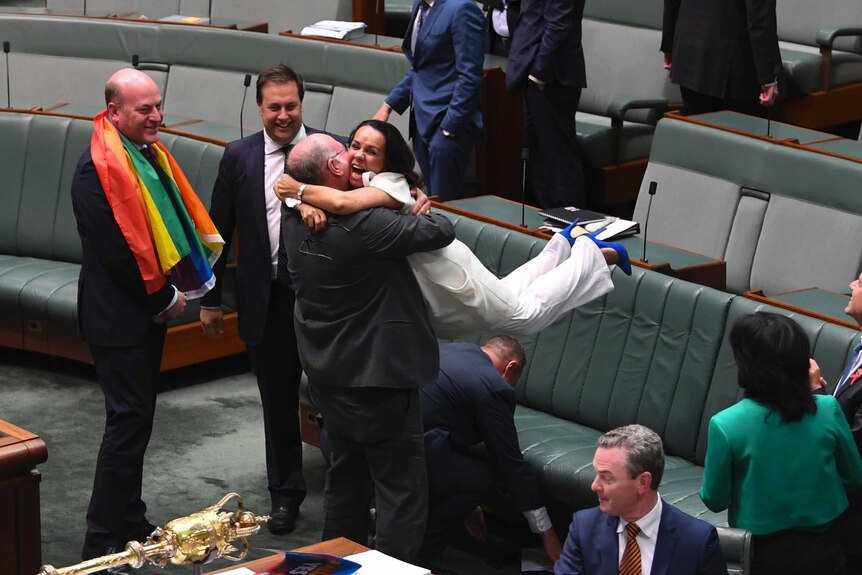 Linda Burney hugs Warren Entsch and throws her feet in the air