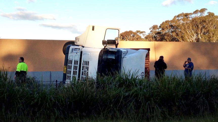 An overturned truck sits on the M7 in Sydney.