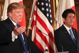 Donald Trump gestures while speaking at a news conference with Shinzo Abe.