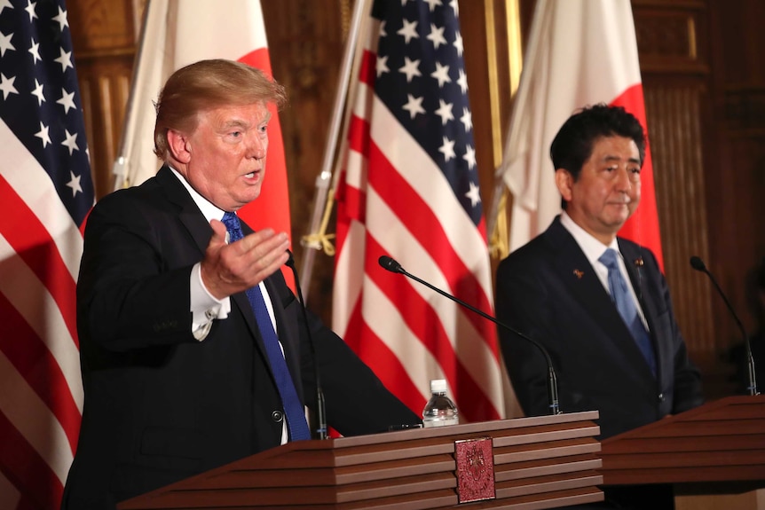 Donald Trump gestures while speaking at a news conference with Shinzo Abe.