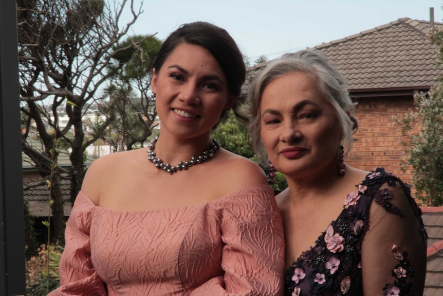 Head shot Jill and Malia standing outside house wearing formal wear.