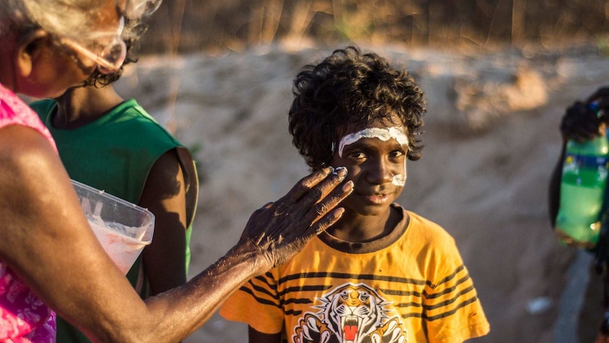 A woman paints a child's face