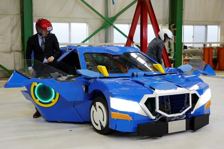 Two men wearing helmets enter the robot in its car form.