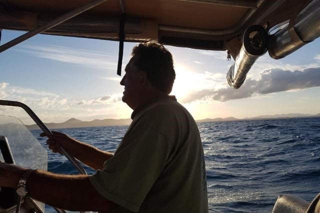 A man on a boat in silhouette.