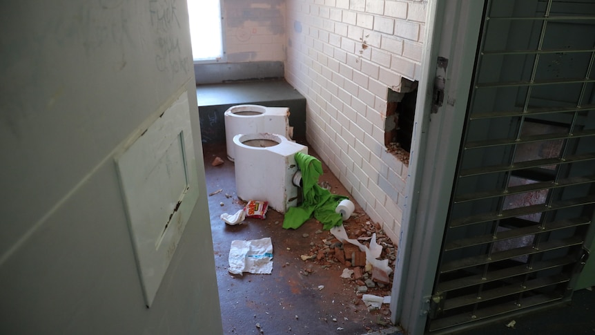 Toilets have been ripped out of walls in a damaged prison cell