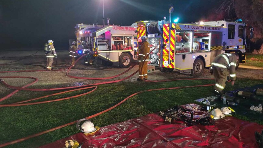 Firefighters and CFS equipment at fire scene at night