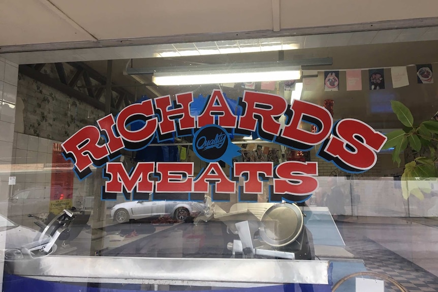 Richard Meats sign with the streets of Bordertown reflected in the window.