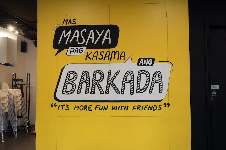 Bright yellow wall sign in Tagalog