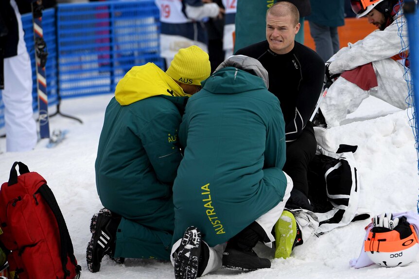 Australian moguls skier Brodie Summers gets assistance for a practice injury at the Winter Olympics.