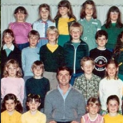 woman in black baseball hat smiling in front of vines and school class photo from the 80s