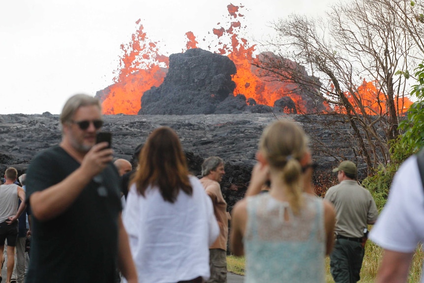 Residents, the media and national guard flock to the end of Leilani Avenue to take in the fiery show.