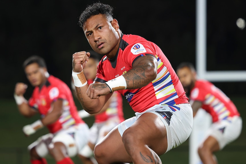 Un joueur de rugby masculin tongan dirige son équipe dans le Sipi Tau.