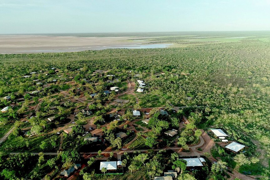 An aerial photo of houses scattered in bush near tidal mudflats 
