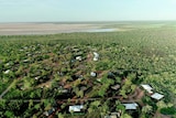 An aerial photo of houses scattered in bush near tidal mudflats 