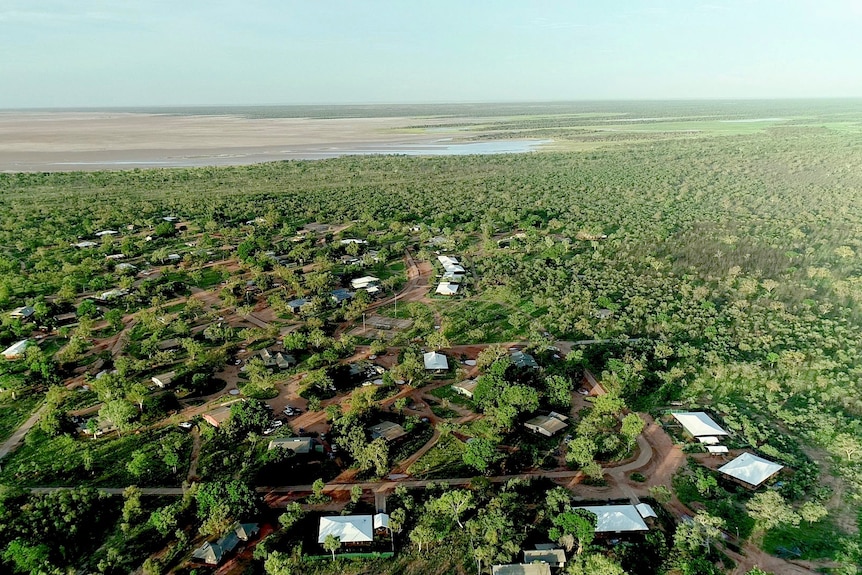 An aerial photo of houses scattered in bush near tidal mudflats 