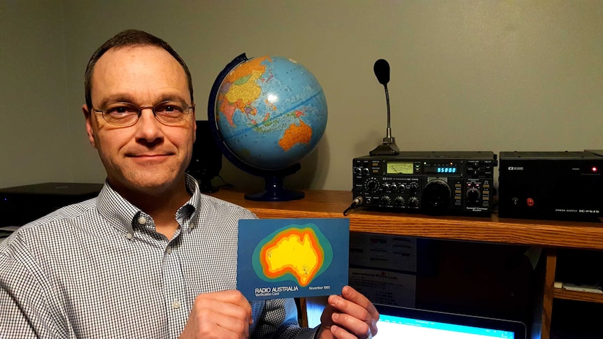 Kevin De Reus sits in his office with his shortwave radio