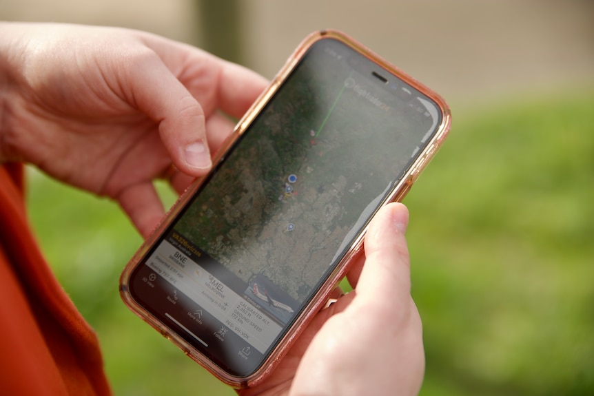 a person holds a phone with a map open on it.