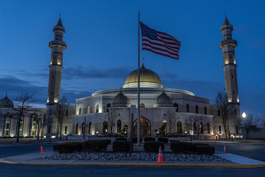 The largest mosque in Dearborn at dusk with an American flag flying in the foreground