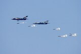 A view of fighter jets against a blue sky