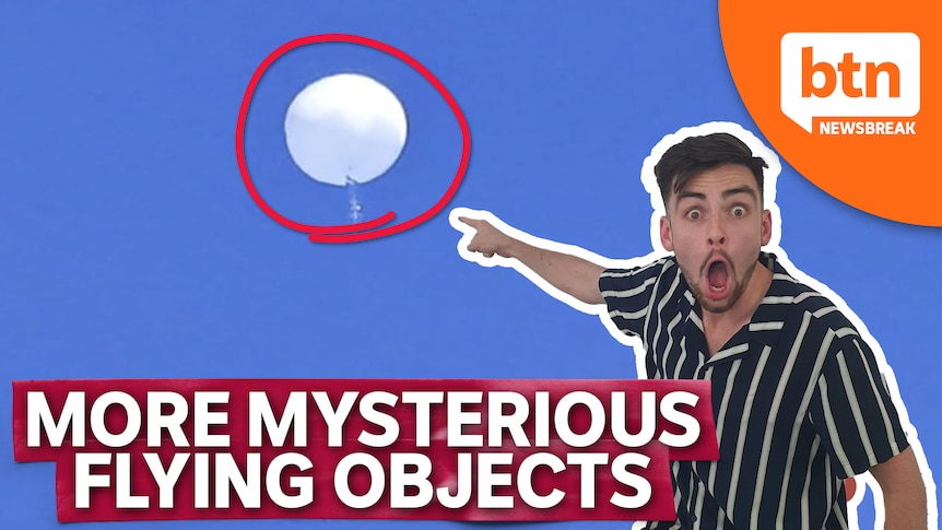 Josh, with a surprised face, points at a white balloon shape object high up in the sky.