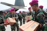 Indonesian military personnel distribute relief aid at Palu's airport.