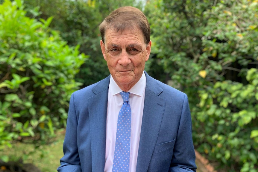 Westpac chief economist Bill Evans stands outside in a garden on a bright day.