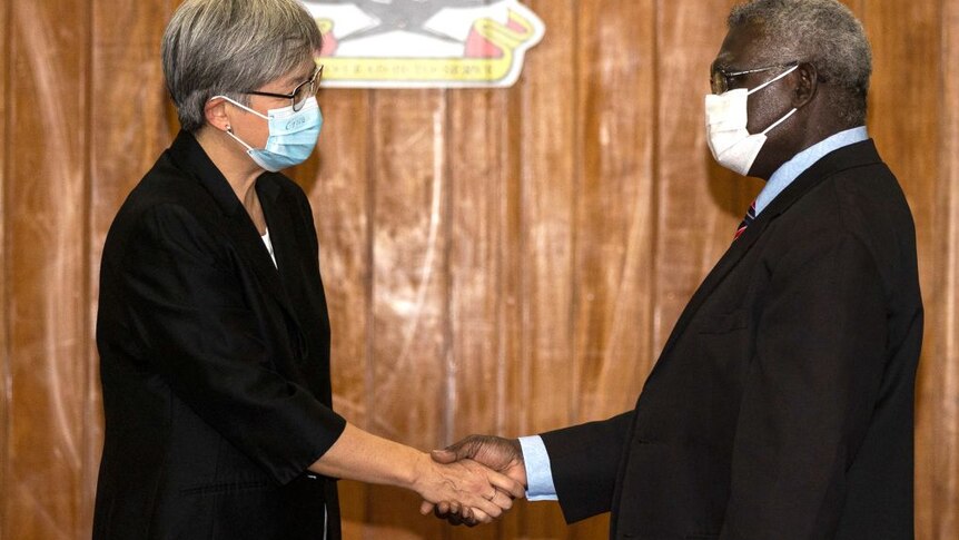 Prime Minister Manasseh Sogavare and Foreign Affairs Minister Penny Wong shake hands in Honiara