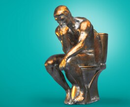 Bronze statue of The Thinker sitting on a toilet.