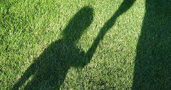 Shadow of a child holding an adult's hand.