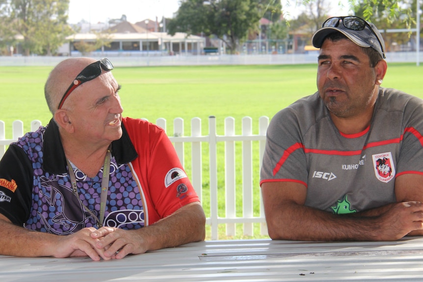 Two men sit at a table