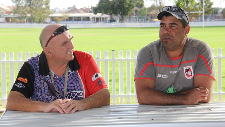 Two men sit at a table