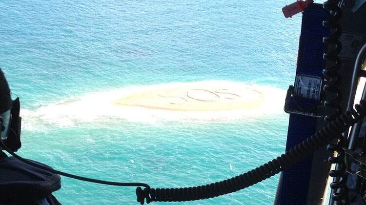 Rescuers spot an SOS message written in the sand