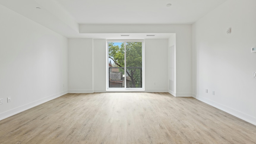 An empty white room with wooden floors. 