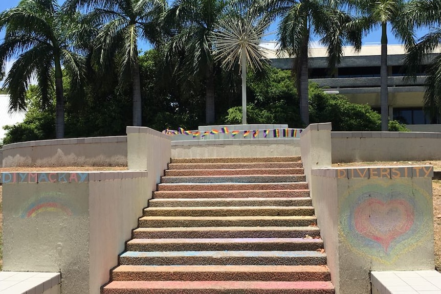 A cement stairway chalked in colours of the rainbow.