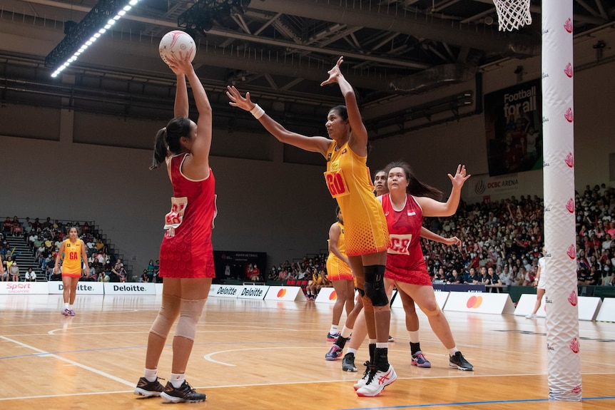 Sri Lanka defends a Singapore shot in the final of the 2022 Asian Netball Championships.