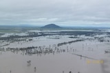 Aerial shot of flood waters across a plain and a small mountain in the distance