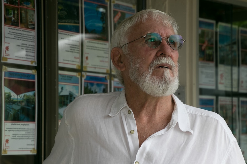 Man in front of real estate listings