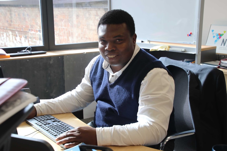 Northern Tasmania Development Corporation population attraction coordinator Edward Obi at his desk, May 2019