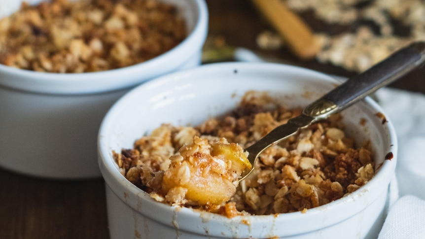 Two ramakins with apple crumble in them.