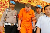 Police officers escort Australian national David van Iersel to a press conference in Bali.