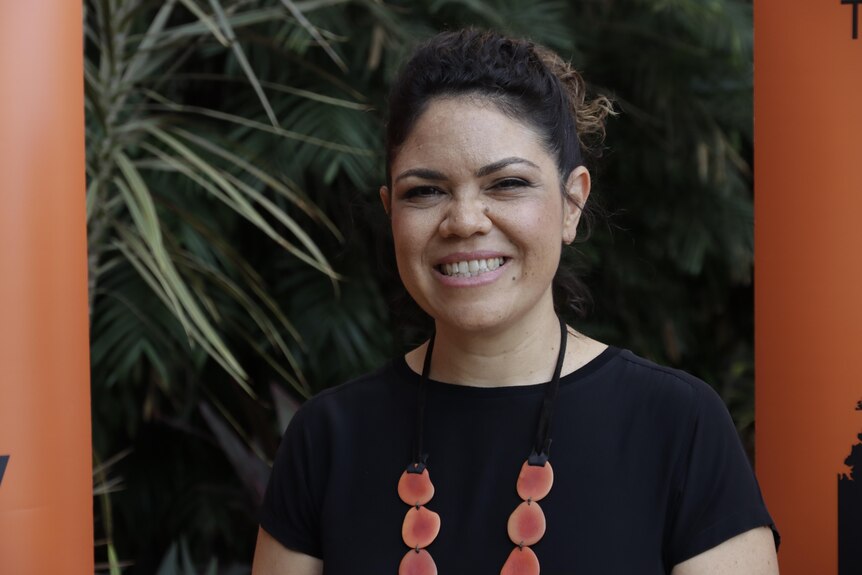 An Aboriginal woman, Jacinta Price, smiling. She's wearing a black shirt and a red necklace.