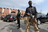 Pakistani policemen stand guard outside The National Stadium