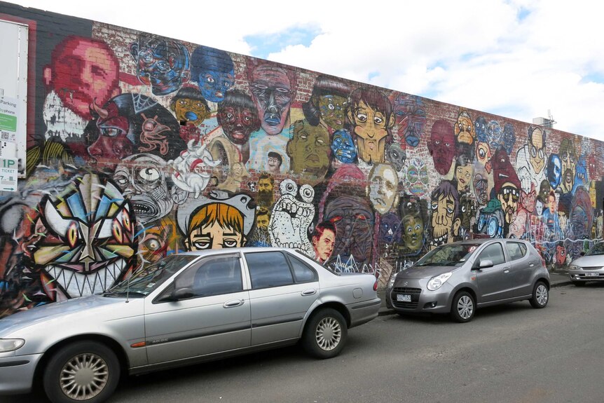 The previous mural, depicting the faces of different people.
