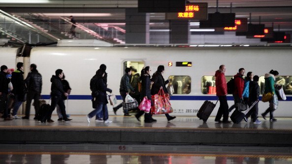 passengers alight a fast train at a Chinese train station